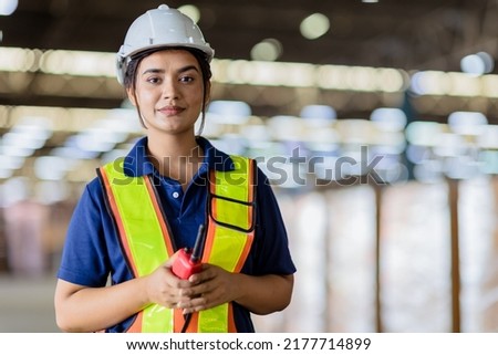 Portrait Indian woman worker supervisor with engineer safety suit work in large factory warehouse Royalty-Free Stock Photo #2177714899