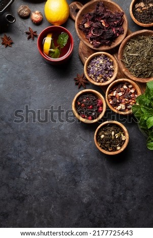 Various dried tea and teapot. Herbal, green, berry and black tea leaves. Top view flat lay with copy space Royalty-Free Stock Photo #2177725643