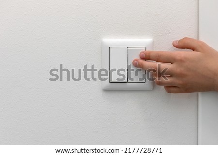 Switching Off the Light, Turning Off Light Switch. Saving concept. Copy space.  Royalty-Free Stock Photo #2177728771