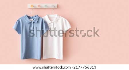 Stylish school uniform hanging on pink wall. Banner for design