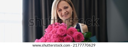 Beautiful young woman get bouquet of flowers on birthday or anniversary Royalty-Free Stock Photo #2177770629