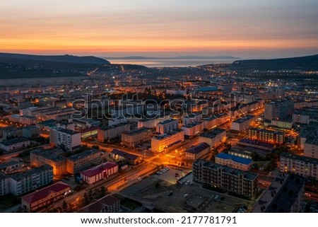 Beautiful morning aerial photograph of the northern city. Top view of the streets and buildings. Dawn. In the distance the sea and hills. City of Magadan, Magadan region, Siberia, Far East of Russia.