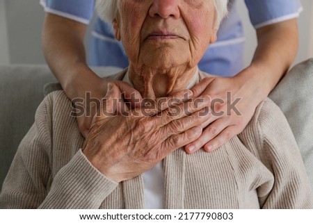 Unrecognizable female doctor expressing care towards an elderly lady, hugging her from behind holding hands. Two adult women of different age. Family values concept. lose up, copy space, background. Royalty-Free Stock Photo #2177790803