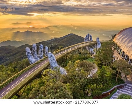 Aerial view of the Golden Bridge is lifted by two giant hands in the tourist resort on Ba Na Hill in Da Nang, Vietnam. Ba Na mountain resort is a favorite destination for tourists Royalty-Free Stock Photo #2177806877