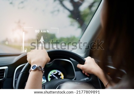 Woman driver driving the modern EV car - electric vehicle on the road and activate auto driving assist and navigation. Land vehicle technology  concept. Royalty-Free Stock Photo #2177809891