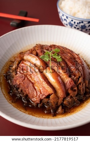 Braised Pork Belly with Preserved Mustard Green  with rice on red background Royalty-Free Stock Photo #2177819517