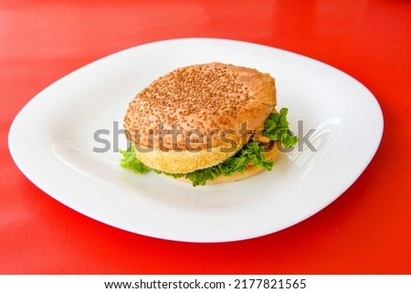 Big tasty burger with beef cutlet on a plate.