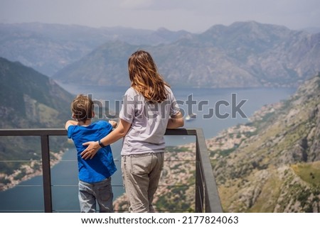Mother and son travellers enjoys the view of Kotor. Montenegro. Bay of Kotor, Gulf of Kotor, Boka Kotorska and walled old city. Travel to Montenegro concept. Fortifications of Kotor is on UNESCO World