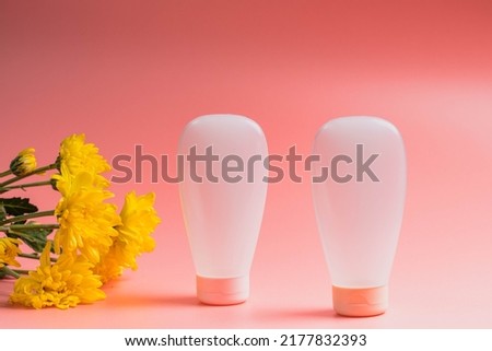 White cosmetic product in tubes on color background. Mock up skincare cosmetic package on pink.