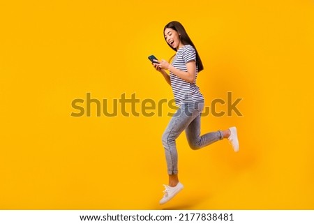 Full size profile portrait of charming person jump hold telephone chatting isolated on yellow color background