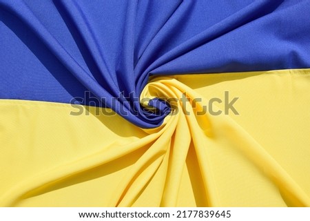 Fabric bent national flag of Ukraine, UA. Blue and yellow colors. Close-up, background.