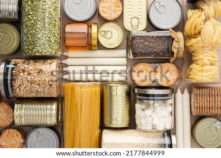 Top view of the background of the necessary products for the period of the pandemic or famine or quarantine and isolation, food stock, the concept of stay at home, donated products, grocery delivery Royalty-Free Stock Photo #2177844999