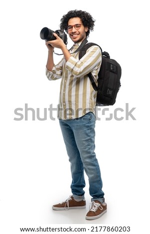 photography, profession and people and concept - happy smiling man or photographer in glasses with digital camera and backpack over white background