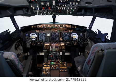 Empty airplane cockpit with electronic flying navigation panel, control command with buttons and lever on dashboard. No people in aircraft cabin to throttle engine and takeoff. Royalty-Free Stock Photo #2177862823