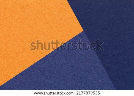 Texture of craft orange and navy blue shade color paper background, macro. Structure of vintage abstract cardboard with geometric shape and gradient. Felt backdrop closeup.