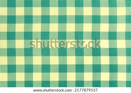 Checkered tablecloth for the table light yellow and green cells pattern. Background texture of olive textile napkin. Plaid fabric. macro. Abstract cyan backdrop.