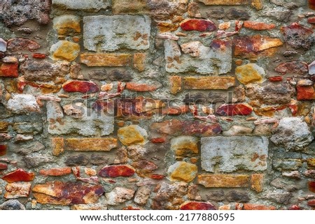 stone wall made of bricks and cobblestones in cement close-up background