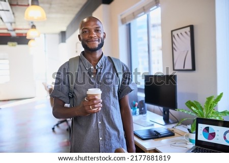A Black trendy man arrives at the office with his coffee and backpack Royalty-Free Stock Photo #2177881819