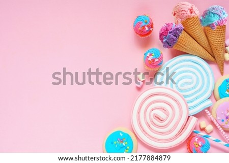 Pastel sweets side border. Ice cream, cookies, cupcakes and an assortment of treats. Above view over a pink background. Copy space.