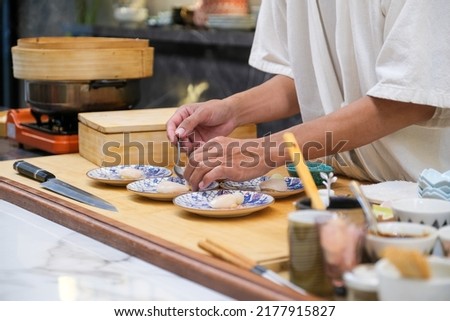 Professional and experienced sushi chef preparing sushi with confident and dedication to his perfect sushi. Royalty-Free Stock Photo #2177915827
