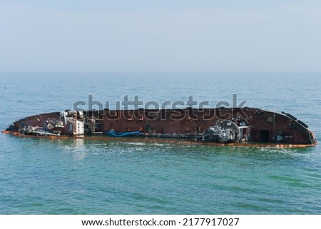 Sunken abandoned ship in water. Ship wreck, storm, tragedy. Destroyed. Metal. Rusty. Shore. Cargo. Sink. Sinking. Corrosion. Rust-eaten. Seascape. Storm. Industrial. Sailing. Damaged Royalty-Free Stock Photo #2177917027