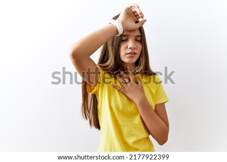 Young brunette teenager standing together over isolated background touching forehead for illness and fever, flu and cold, virus sick 