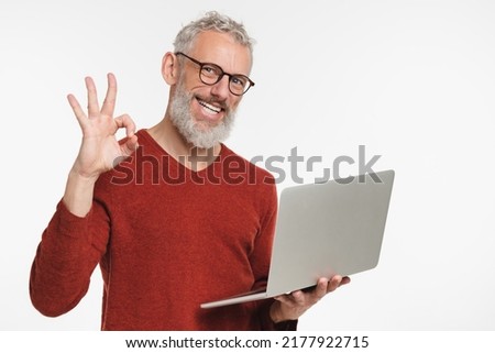 Caucasian mature middle-aged freelancer businessman ceo manager using laptop for online shopping, remote work, e-learning e-commerce showing okay gesture isolated in white