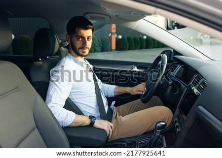 Protection of a person in vehicles. Fasten your body with a seat belt in the car. Bearded man fastens car seat belt with hand. Compliance with safety rules for driving. Road safety regulations concept Royalty-Free Stock Photo #2177925641