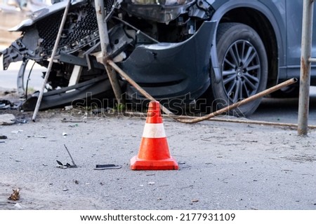 road cone against the background of a car broken in a road accident. Selective focus Royalty-Free Stock Photo #2177931109
