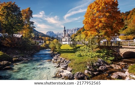 Beautiful nature landscape. Incredible autumn scenery. Scenic mountain landscape in the Bavarian Alps. Small church on the river bank.view on famous Parish Church of St. Sebastian