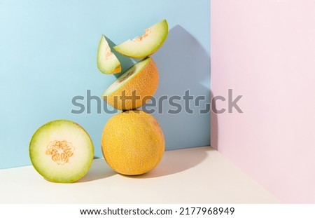 Minimal abstract creative summer fruit scene made of slices of juicy, fresh melon standing on isolated pastel beige, pink and blue background with copy space. Aesthetic concept of raw healthy food. Royalty-Free Stock Photo #2177968949