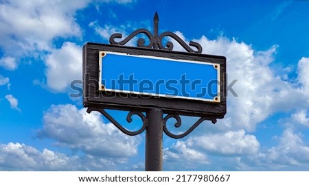 old metal signpost on blue sky background