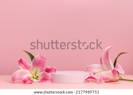 Podium with pink lily, round cylinder scene with flowers on pink background, display for cosmetics, perfume and product presentation Royalty-Free Stock Photo #2177989751