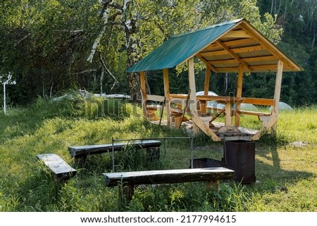 Equipped parking for a picnic, a canopy from the rain in the campsite, a place for making a fire in nature, a paid parking lot for outdoor recreation. High quality photo