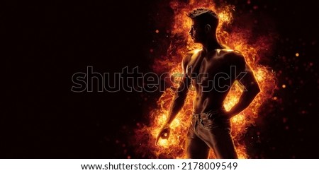 Brutal strong athletic Bodybuilder posing. Fire and spark explosion in the background. Bodybuilding and healty life concept.