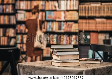 Close-up of stops of books, book store, library. Silhouette of abstract girl. Education, school, study, reading concept. Blurred background Royalty-Free Stock Photo #2178019539