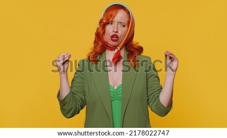 Gossips. Liars. Redhead young woman showing bla-bla-bla nonsense gesture with hands and rolling eyes, gossips, empty promises, blah concept. Adult ginger girl indoors isolated on yellow background Royalty-Free Stock Photo #2178022747