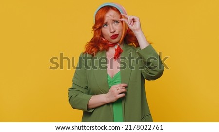 Need some more please give me. Woman showing a little bit gesture with sceptic smile, showing minimum sign, measuring small size asking for help. Ginger girl isolated alone on yellow studio background