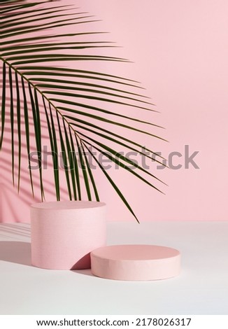 Pastel pink composition with product podium and green palm leaf. Suitable for Product Display and Business Concept. Modern aesthetic. Royalty-Free Stock Photo #2178026317