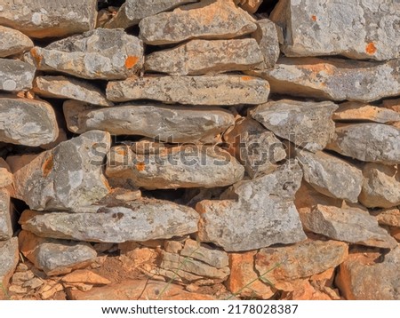 Detail of traditional drywall as a fence of dirt road in Promina county in Croatia. Croatian drywall construction is a protected intangible cultural heritage of humanity by UNESCO. Royalty-Free Stock Photo #2178028387