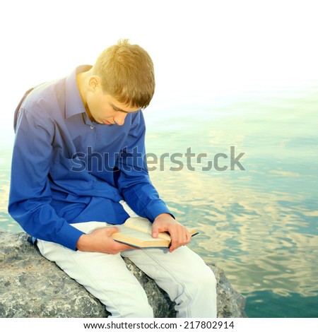 Toned photo of Teenager reading a Book near the Water