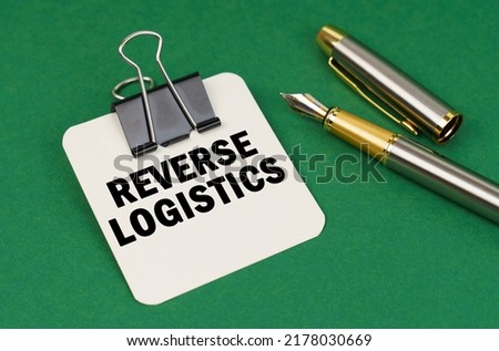 Business and industry concept. On a green surface, a pen and a sheet of paper with the inscription - Reverse logistics Royalty-Free Stock Photo #2178030669