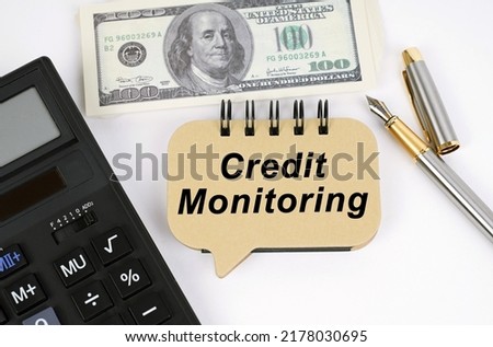 Business concept. On a white surface, a calculator, dollars, a pen and a sign with the inscription - Credit Monitoring