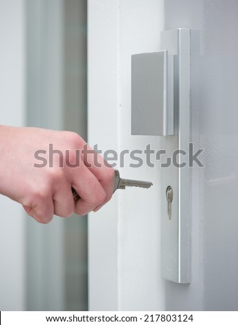 Close up female hand unlocking door lock