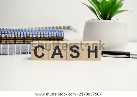 word cash on wooden blocks and notepads