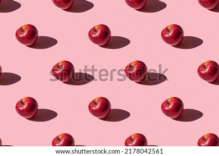 seamless pattern of a photo of a ripe red apple on a pink background