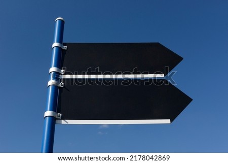 Entrance sign with direction arrow on the blue sky.
