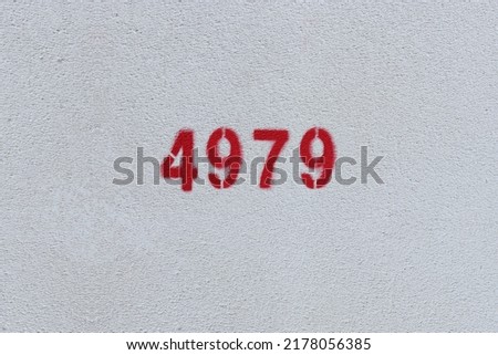 Red Number 4979 on the white wall. Spray paint.
