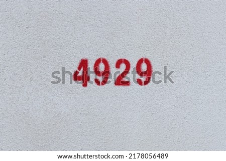 Red Number 4929 on the white wall. Spray paint.
