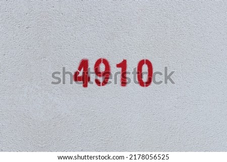 Red Number 4910 on the white wall. Spray paint.
